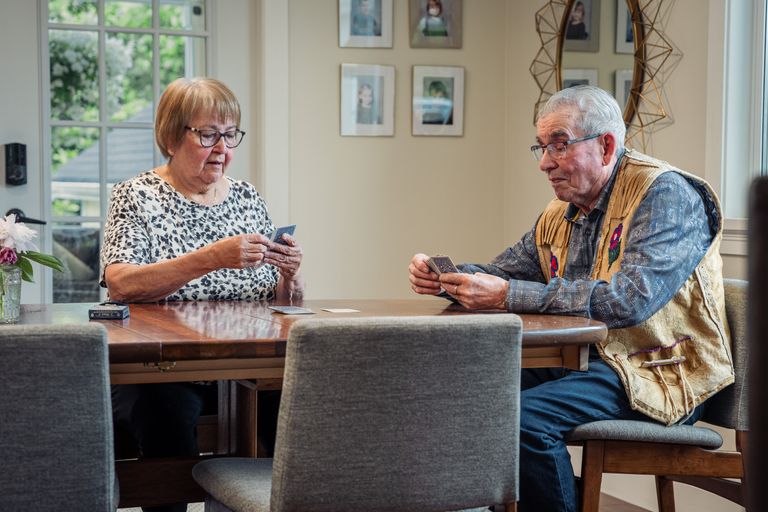 Senior couple enjoying a card game indoors, showcasing leisure and companionship.